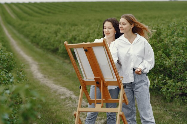 Элегантные и красивые девушки рисуют в поле