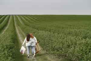 Free photo elegant and beautiful girls painting in a field