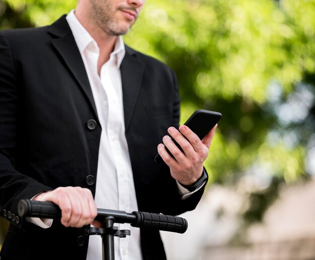 Elegant businessman riding scooter outdoors