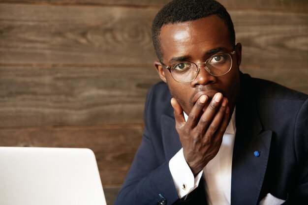 Elegant businessman sitting in cafe with laptop