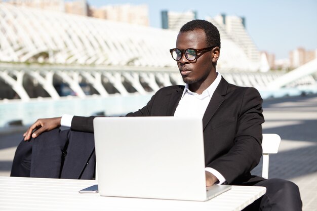 Elegant businessman with laptop outdoors