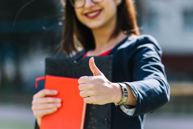 Elegant businesswoman doing thumbs up outdoors