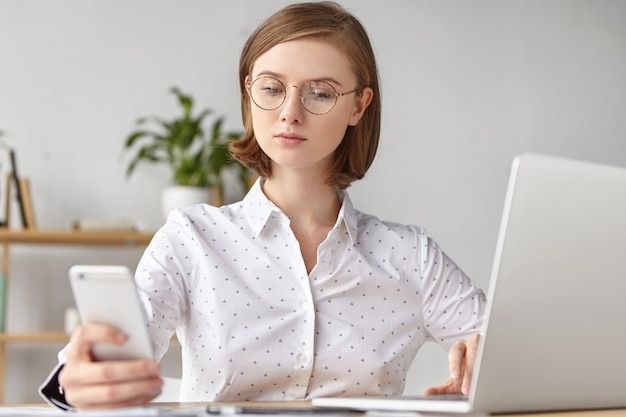 Elegant businesswoman dressed formally sitting with laptop