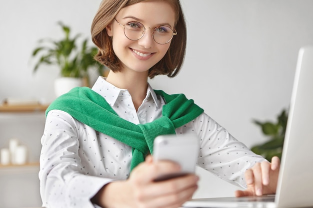 Elegant businesswoman dressed formally sitting with laptop