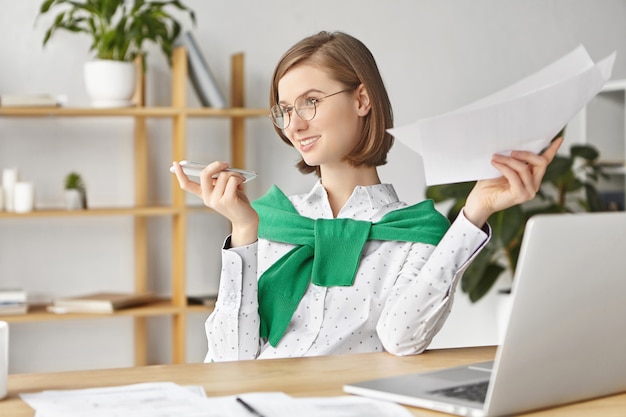 Elegant businesswoman dressed formally sitting with laptop