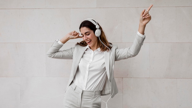 Элегантная деловая женщина слушает музыку в наушниках