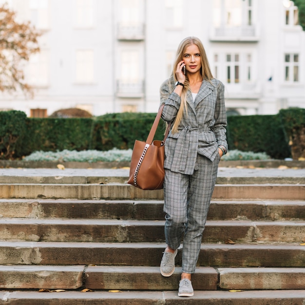 Free photo elegant businesswoman making phone call in city