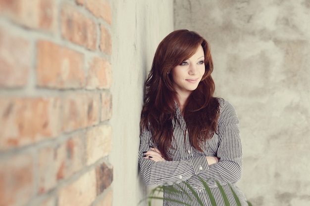 Elegant businesswoman posing on concrete wall