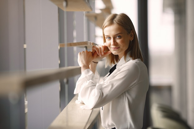 Donna di affari elegante che sta nell'ufficio