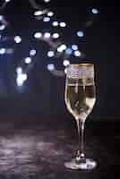 Free photo elegant champagne glass on textured surface at night party