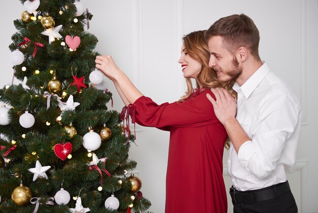 Elegant couple decorating the christmas tree