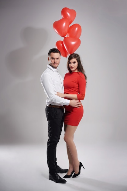 Foto gratuita coppia elegante in posa con palloncini