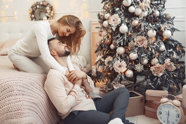 Elegant couple sitting at home near christmas tree