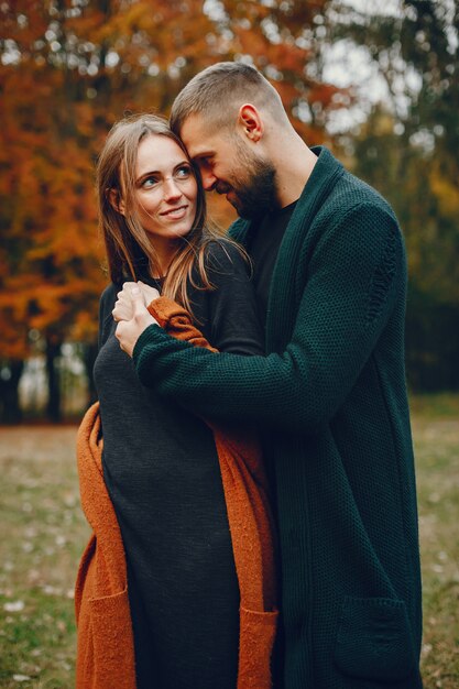 Elegant couple spend time in a autumn park