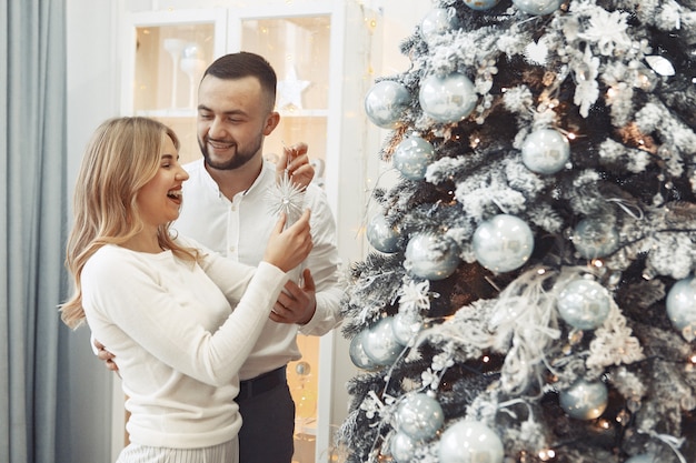 Elegant couple standing at home near christmas tree