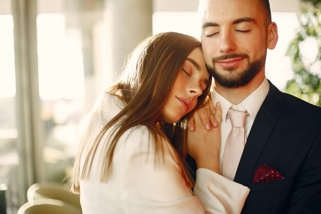 Elegant couple in a suits spend time in a cafe