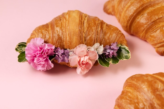 Foto gratuita elegante concetto di cibo ecologico con fiori in croissant