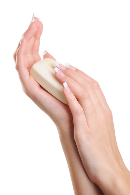 白い石鹸を持っているエレガントな女性の手