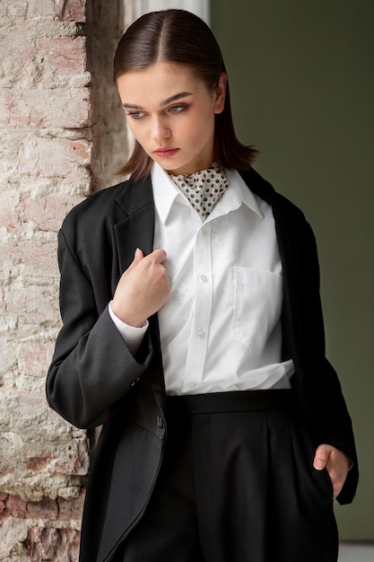 Free photo elegant female model posing in a jacket suit with a tie. new feminity concept