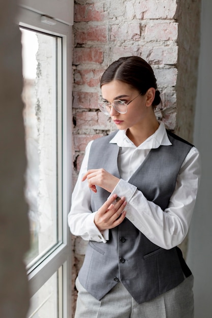 Elegant female model posing in a window in elegant waistcoat. new feminity concept