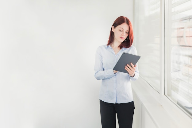 Elegant female worker browsing tablet