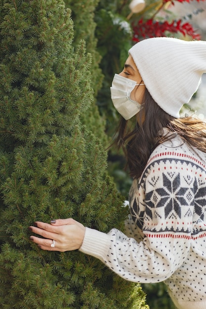 Elegant girl buys a Christmas tree.