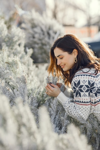 La ragazza elegante acquista un albero di natale.