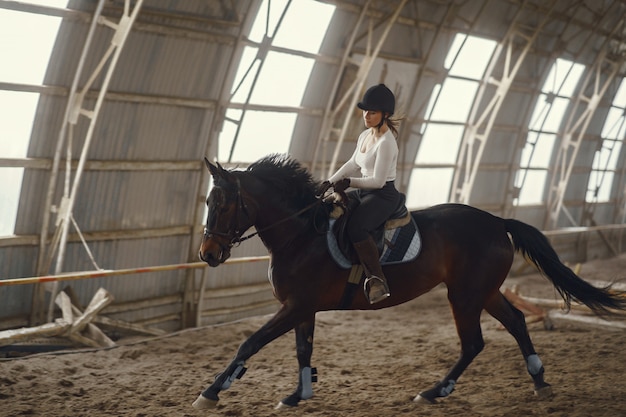 Бесплатное фото Элегантная девушка на ферме с лошадью