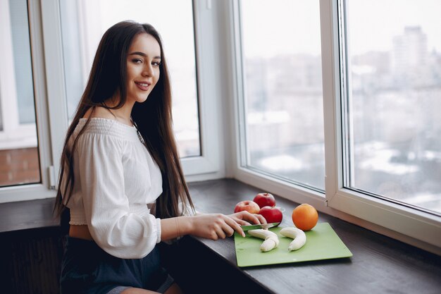 Elegant girl in a kitchen with fruits
