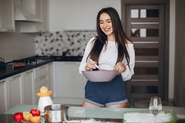 Free photo elegant girl in a kitchen with fruits