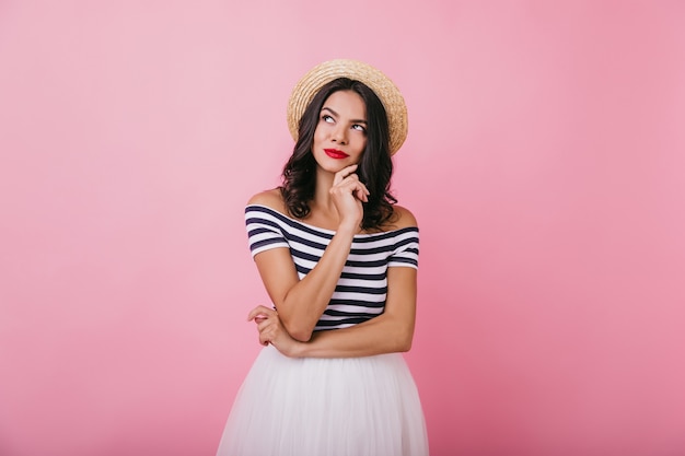 Elegant girl with tanned skin posing with pensive face expression