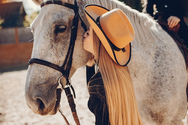 牧場で馬を持つエレガントな女の子
