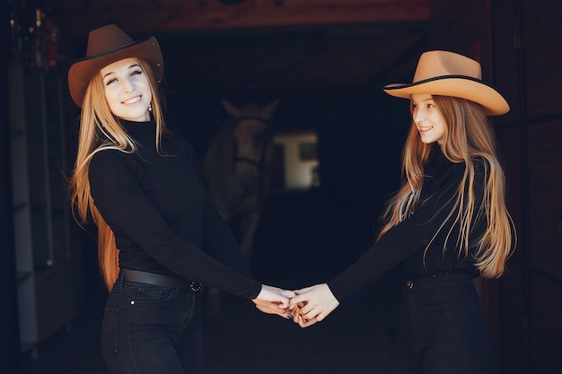 Elegant girls with a horse in a ranch