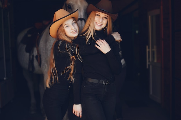 Elegant girls with a horse in a ranch