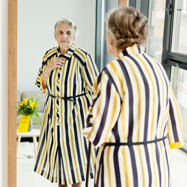 Elegant grandmother looking at herself in the mirror