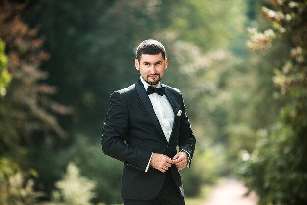 Elegant groom posing outdoors