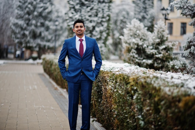 Elegante modello indiano uomo alla moda in abito posato al giorno d'inverno