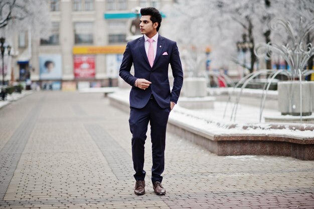 Elegant indian macho man model on suit and pink tie posed on winter day