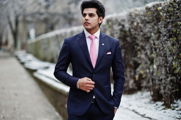 Elegant indian macho man model on suit and pink tie posed on winter day