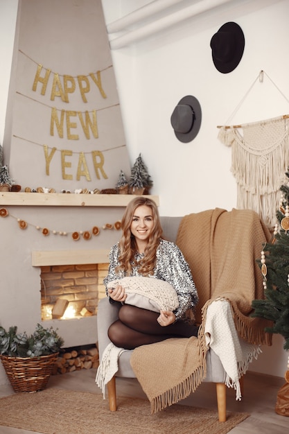 Elegant lady near Christmas tree.