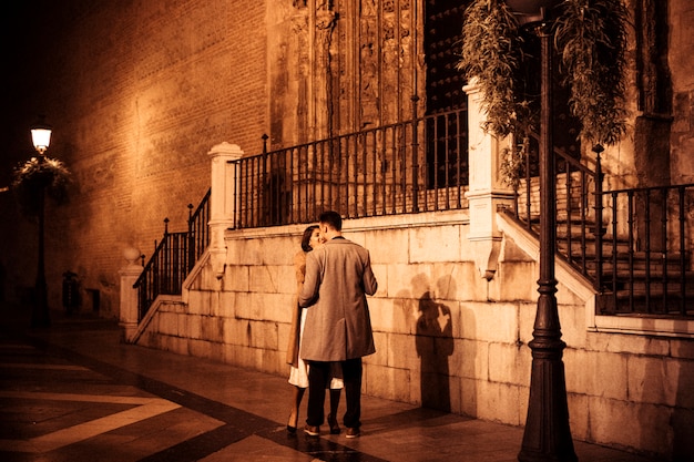 Elegant lady near young guy on street in evening