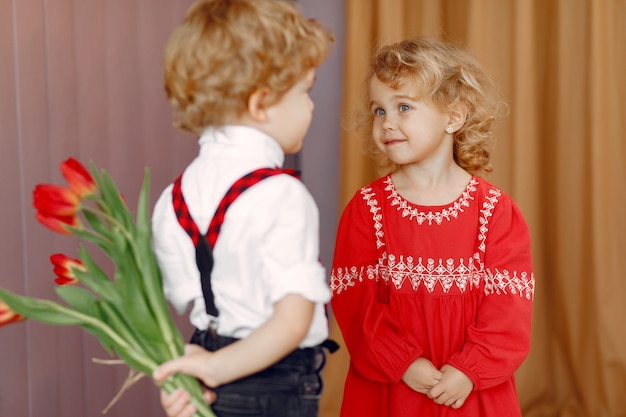 チューリップの花束を持つエレガントな小さな子供