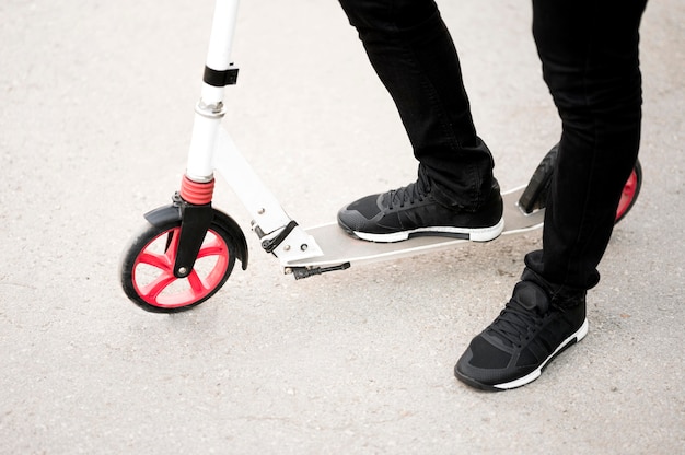 Elegant male riding scooter outdoors