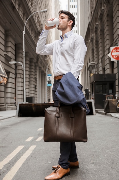 Elegant man drinking on street