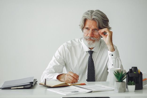 Elegant man in office. Businessman in white shirt. Man works with documents.