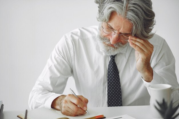 Elegant man in office. Businessman in white shirt. Man works with documents.