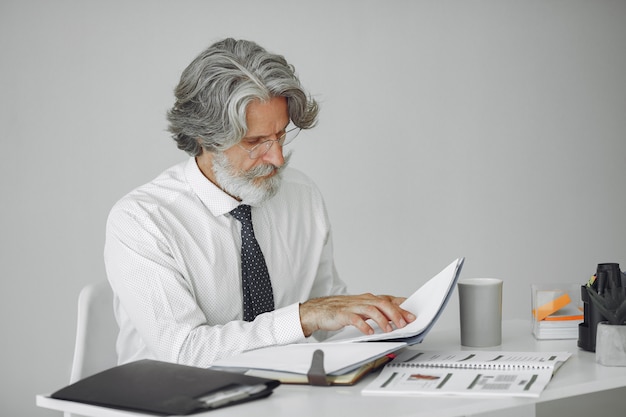 Elegant man in office. Businessman in white shirt. Man works with documents.