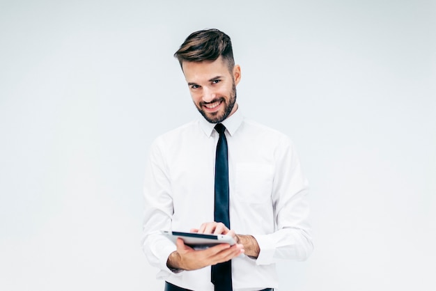 Elegant man smiling while watching a tablet