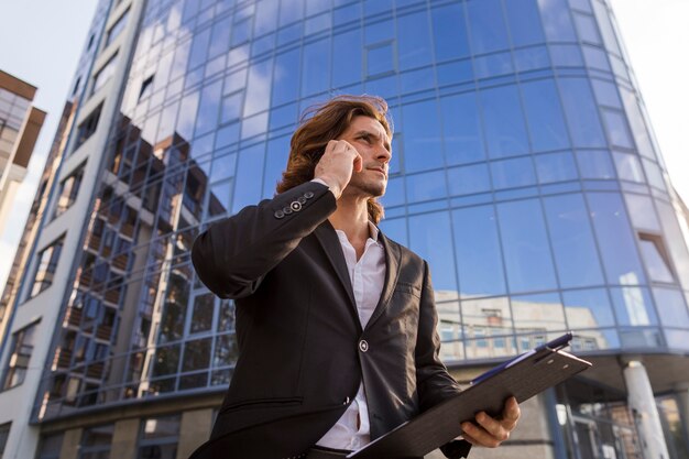 Elegant man talking at phone low angle shot