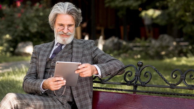 Elegant mature male holding tablet